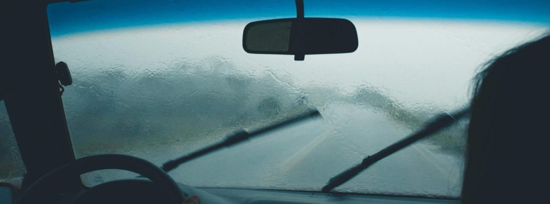 Windshield wipers keep visibility up on a vehicle driving in the rain.